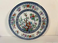 Full view of English antique porcelain plate with floral pattern and decorative border.