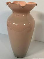 Full view of peach-colored ceramic vase showing the height, shape and glossy finish.