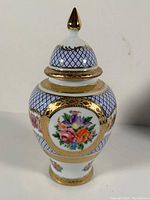 Front view of the Limoges porcelain urn with floral designs and gold plate detailing.