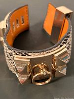 Close-up of bracelet showing textured leather with metal studs and ring detail