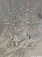 Eight crystal wine glasses arranged in two rows showing diamond and wedge cut pattern