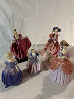 Group photo of all five figurines on a plain background showing front views