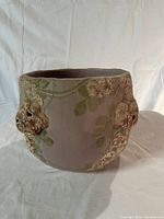 Overall view of antique ceramic planter showing full circular shape, taupe color with raised floral motifs