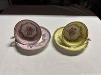 Two Grosvenor teacups with saucers, one yellow and one pink, showing both sets side by side.