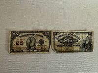 Photo showing two Dominion of Canada 25 Cents bills, one from 1900 and one from 1923, with visible wear and tear.