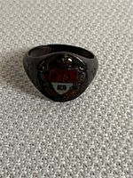 Front view of sterling silver insignia ring with colored red and white crest featuring a fleur-de-lis.