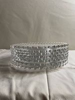 Side stacked view showing five clear glass plates with beaded edges stacked securely.