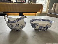 Side view of Royal Albert blue and white creamer and matching bowl on table