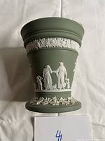 Angled side view showing the green jasperware flower holder with white relief classical figures and garlands.