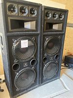 Photo of two black Power Pro Audio speakers about 2 feet tall with multiple drivers and port holes in textured cabinets.