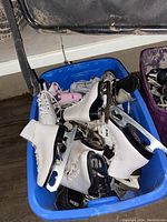 Single blue plastic tote showing white figure and black hockey skates