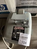 Photo of gray Mastercraft wet knife sharpener with a sharpening guide, label, and power cord visible.