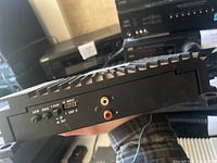 Close-up of amplifier side panel showing gain, bass boost, crossover control knobs, and RCA input jacks L and R.