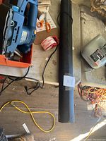 Image of a long black Polk sound bar placed horizontally on a surface with its power cable. The sound bar is visible along with nearby electrical cables and other tools.