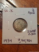 Front side of the 1934 UK Silver 3 Pence coin in a white cardboard holder with inscriptions indicating details.