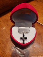 Cross pendant and chain displayed in a red heart-shaped velvet jewelry box, showing overall look and presentation.