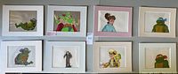 Overview of eight white-matted animation cels arranged two rows of four