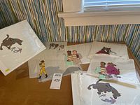 Overhead view of multiple animation cels displayed on table against striped wallpaper
