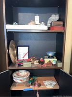 Wide view of shelving unit filled with various Asian decorative boxes, containers, bowls and ornaments