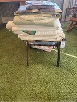 Stack of bedding and quilts on folding luggage rack