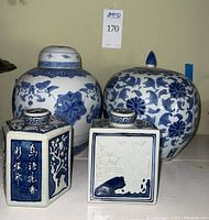 Photo of 2 large blue and white Asian ginger jars and 2 hexagonal ceramic decanters with lids, showing detailed raised designs and traditional motifs.