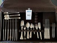 Brown leather case open showing all flatware pieces held in felt loops