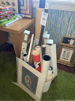 Collection of numerous rolled posters in cardboard tubes and boxes arranged on floor