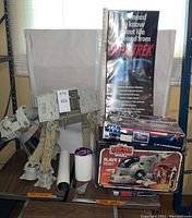 Overview of AT-AT Walker, Star Trek poster, X-34 Landspeeder kit, Slave I model kit box, and storage cylinders.