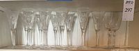 Fourteen stemmed crystal glasses: twelve slender champagne flutes in various patterns and two larger goblets
