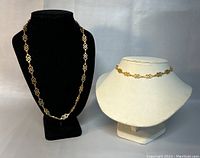 Photo showing two vintage D'orlan necklaces displayed on black and white bust forms.