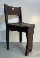 Side angle view of the antique oak wood three-leg chair highlighting the seat, backrest, and side profile of the unique leg design.