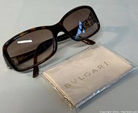 Bvlgari sunglasses displayed with original Bvlgari cleaning cloth in packaging