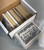 Box showing large quantity of assorted football and baseball cards packed tightly, vintage style cards visible.