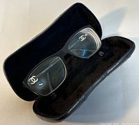 Pair of eyeglasses seated inside open quilted case