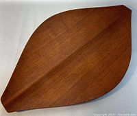 Top view photo showing the teak wood tray's leaf shape and wood grain surface