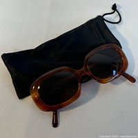 NOTORIO sunglasses shown with a black soft pouch, top view