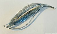 Front angled view of vintage BEAU sterling silver leaf brooch showing detailed vein etching and curved design.