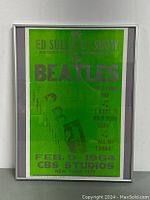 Front view of framed Beatles Ed Sullivan Show poster with green background and silver text.