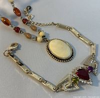 Close-up of the necklace pendant and bracelet showing design details and materials