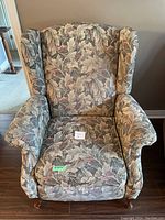 Front view of the armchair showing the overall upholstery pattern and wood legs.