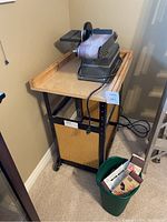 Belt and disc sander mounted on wheeled cart against wall