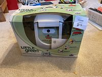 Front view of Bissell Little Green cleaner in original packaging showing main unit and branding.