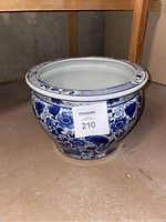 Blue and white ceramic planter pot showing full side profile with floral and bird motifs and wide rim with lattice design