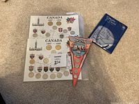 Full view of two Canada coin boards dated 1867-1992 with coins and a sealed 2 cents coin folder along with the Costa Rica coin plaque