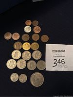Coins arranged on dark cloth showing various British and Irish coinage including pennies, three pence, one shilling and a half crown coin.