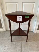 Front view of the wooden triangle or round side table with triple drop-leaf and lower shelf