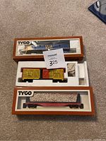 Overview of all three TYCO train items in original packaging: VIA train engine, KC Durango freight cage car, Southern Railroad center beam coal car.