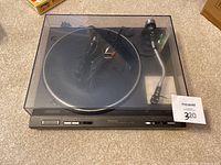 Full view of Technics SL-1200MK2 turntable with dust cover closed showing top view and power/cable attached.