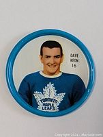 Front side of the metal hockey coin showing Dave Keon in a blue Toronto Maple Leafs jersey with his number 16 and name printed.