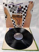 Vinyl record LP placed on a partially open cover, showing overall condition of record and cover.